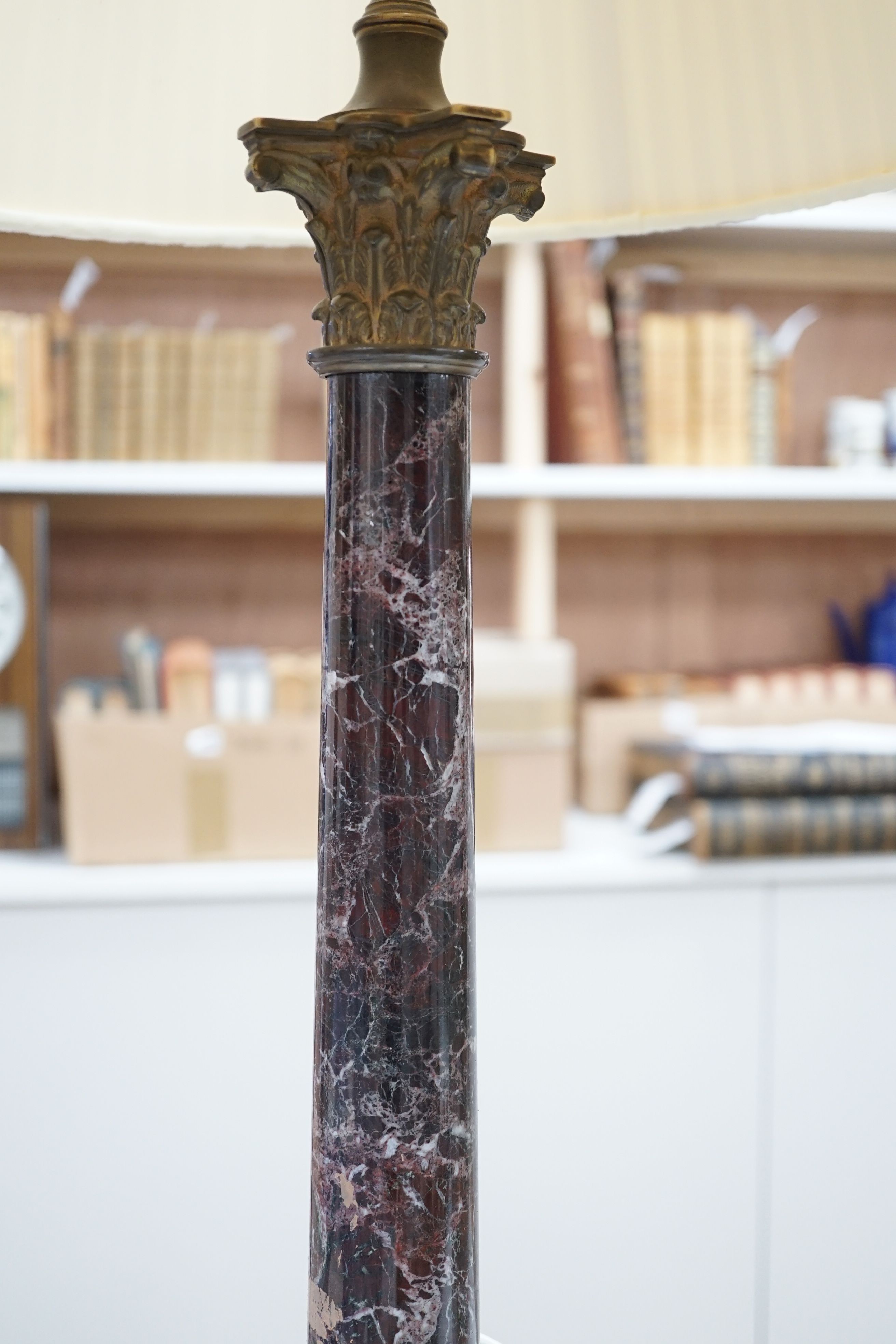 A brass and variegated marble Corinthian column lamp base, 47cms high, not including light fitting.